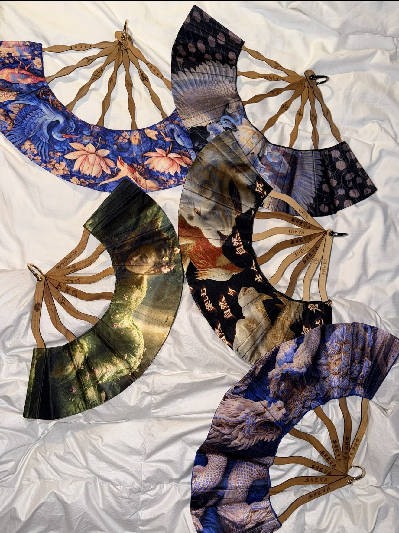 Silk fans with engraved wooden ribs laid out on white linen